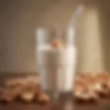 A glass of cashew milk surrounded by cashews and almonds.