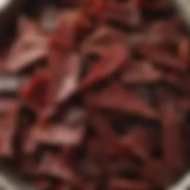 A variety of flavored beef jerky pieces arranged in a bowl.