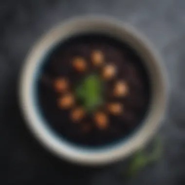 A bowl of Riso al Nero di Seppia, showcasing black rice cooked with cuttlefish, garnished with fresh herbs.