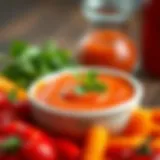 A close-up view of vibrant red spicy buffalo sauce in a small bowl, surrounded by fresh ingredients.